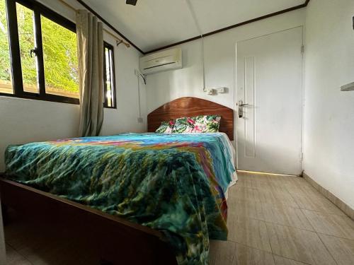 1 dormitorio con 1 cama en una habitación pequeña en My Ozi Perl Studio en Anse Kerlan