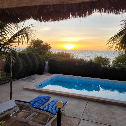 a swimming pool with a view of the ocean at la villa sur la plage in Palmarin