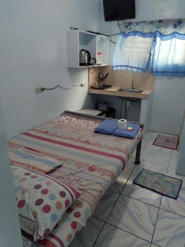 a small room with a bed and a sink at Angeles City Guesthouse in Angeles