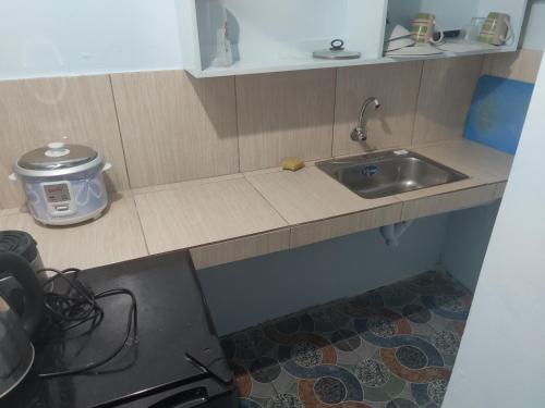 a kitchen with a sink and a counter top at Angeles City Guesthouse in Angeles