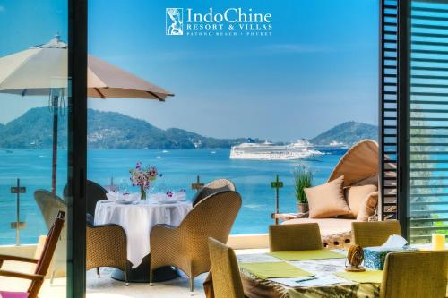 a restaurant with a view of the ocean and a cruise ship at IndoChine Resort and Villas in Patong Beach