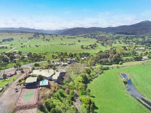 an aerial view of a farm with mountains in the background at Off Mountain Accommodation in Merrijig