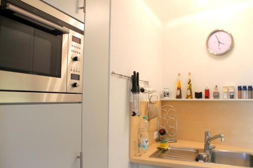 een keuken met een wastafel en een magnetron bij Hanseat II - Whg 183 "Meeresperle" in Grömitz