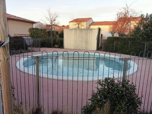 a swimming pool behind a fence at BASTIDON EN PROVENCE in Aubignan