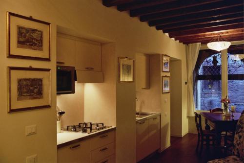 a kitchen with a table and a dining room at Al pozzo dei Scoacamini, 100 m from San Marco, ground floor in Venice
