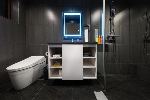 a bathroom with a toilet and a sink with a mirror at Bluebird Apartments by The Hakuba Collection in Hakuba