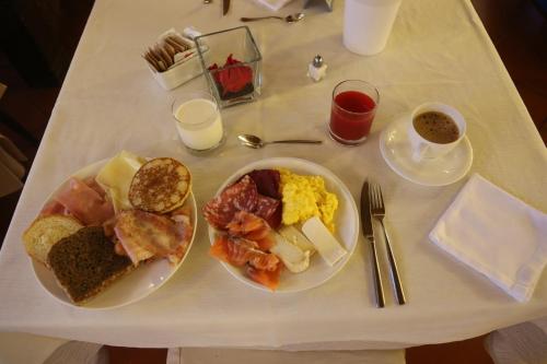 a table with two plates of breakfast food on it at Hotel Baita Clementi in Bormio