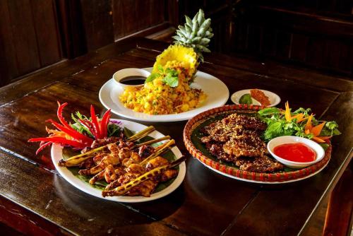 drie borden eten op een houten tafel bij Nhà Nghỉ Hồng Nhung in Mai Chau
