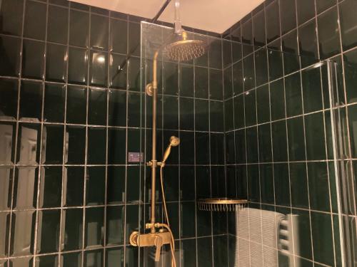 a shower in a bathroom with green tiled walls at 15 Grosvenor in Hastings