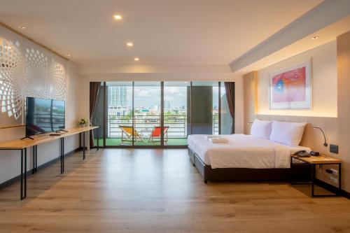 a hotel room with a bed and a large window at The Royal River Hotel in Bangkok