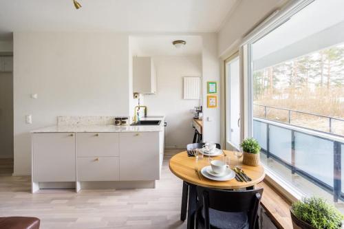 a kitchen with a table and a large window at Eastend Pearl - Studio with great kitchen - subway and shops near in Helsinki