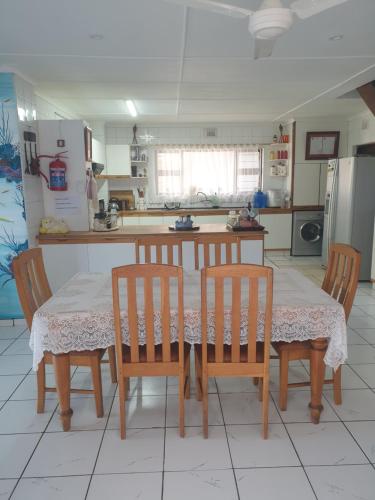 a kitchen with a table and chairs and a kitchen with a refrigerator at Deep Blue Guest House in Amanzimtoti