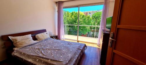 een slaapkamer met een bed en een groot raam bij Coeur de ville maison piscine in Saint-Raphaël