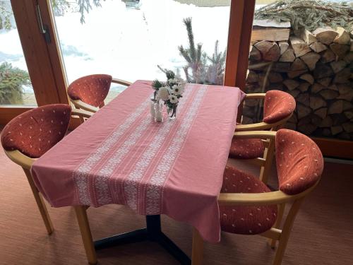 a dining room table with a pink table cloth and chairs at Penzion Limba in Belá