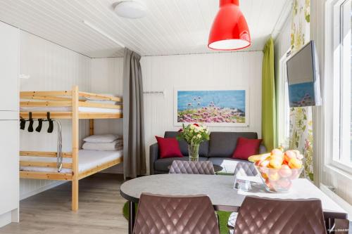 een woonkamer met een tafel en een stapelbed bij First Camp Åhus-Kristianstad in Åhus