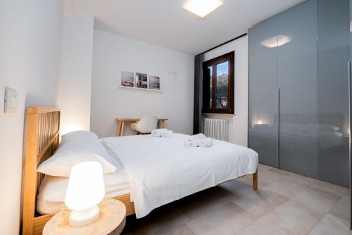 a bedroom with a white bed and a glass wall at Riviera degli Ulivi - Terrace over the castle in Torri del Benaco
