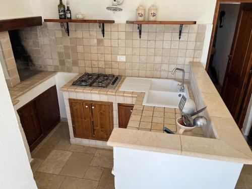 uma cozinha com um lavatório e um fogão em Casa Giuliveto - Charmantes Ferienhaus mit Privatpool in Olivenhain em Ostuni