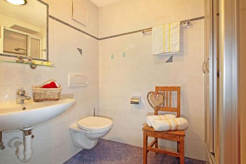 een witte badkamer met een wastafel en een toilet bij Niederhaeusererhof in Falzes