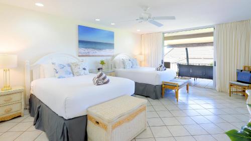 ラハイナにあるMaui Eldorado B200-Large lanai w/ocean/golf course viewsのベッド2台とバルコニーが備わるホテルルームです。