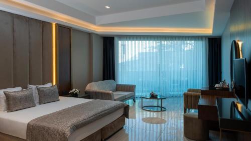 a bedroom with a bed and a living room at Vogue Hotel Supreme Bodrum in Torba