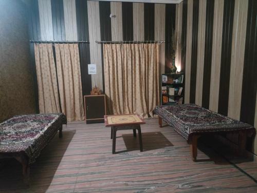 una camera con due letti e un tavolo di Shri Devbhoomi homestay a Haridwār