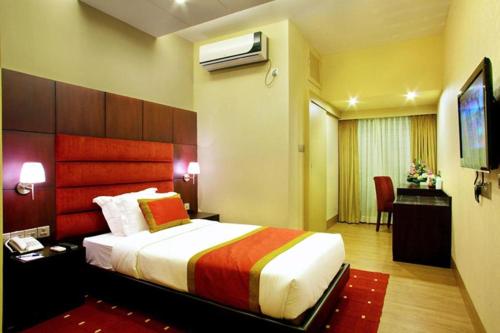 um quarto de hotel com uma cama e uma secretária em West Park Inn em Daca