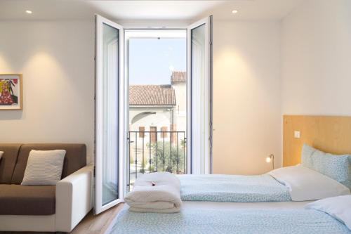 クレモナにあるB&B FIERA "in cascina"のベッドルーム1室(ベッド1台、大きな窓付)