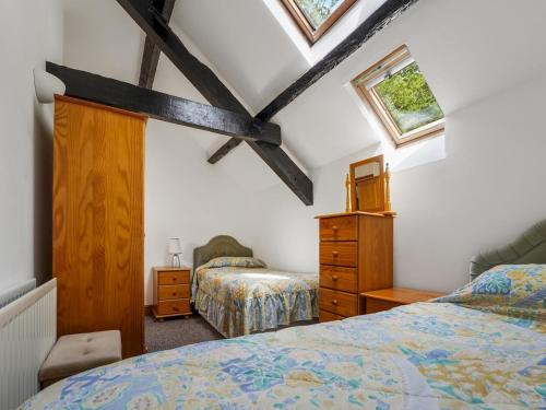 Tregaron的住宿－Pass the Keys Cosy 3 Bedroom Barn Conversion with pool，阁楼卧室配有两张床和梳妆台