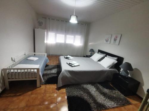 Un dormitorio con una cama grande y una ventana en O Mercadinho, en Poiares