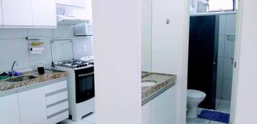 uma cozinha branca com pia e fogão em Melhor localização em Boa Viagem! em Recife