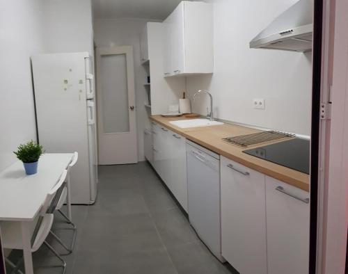トレモリノスにあるModerno apartamento con piscinaの白いキッチン(白いキャビネット、シンク付)