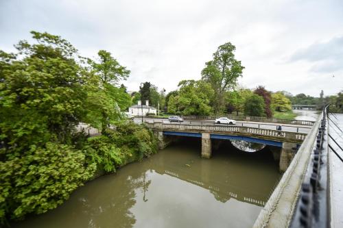 a bridge over a river with cars on it at Terrace House in Leamington Spa