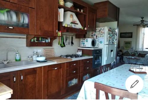 a kitchen with wooden cabinets and a white refrigerator at Casa Merlino in Comazzo