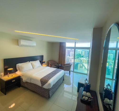 a hotel room with a bed and a large window at Dweik Hotel 2 in Aqaba