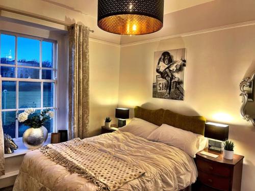 een slaapkamer met een groot bed en een raam bij TWO BEDROOM Private development & concierge in Plymouth