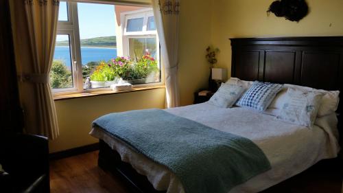 - une chambre avec un grand lit et une fenêtre dans l'établissement The Plough B&B, à Ventry