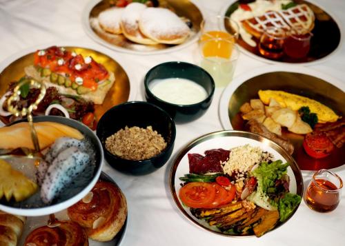 a table with many plates of food on it at The Coach Hotel Sukhumvit - Asok BTS Bangkok in Bangkok