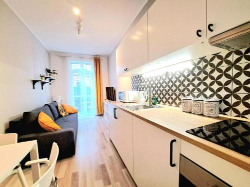 kuchnia i salon z kanapą w obiekcie Hey Stay Apartment with private garden w Toruniu