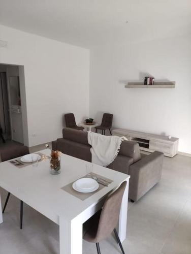uma sala de estar com uma mesa branca e um sofá em Patacchella House em Ostuni
