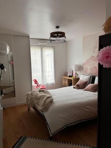 ein Schlafzimmer mit einem großen Bett und einem großen Fenster in der Unterkunft Appart 2 chambres 17 min de Paris in Rosny-sous-Bois