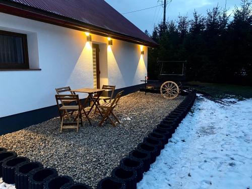 a patio with a table and chairs next to a house at Domek Góralski na Ubocy z jacuzzi in Białka Tatrzanska
