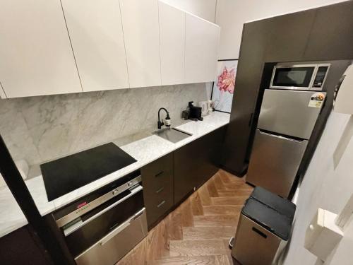 a small kitchen with a sink and a refrigerator at The Italian New Yorker in Sydney