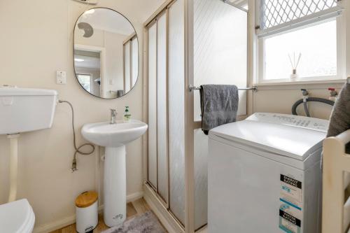 a small bathroom with a sink and a mirror at Carrington Countryside - New Plymouth Holiday Home in New Plymouth