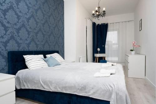 a bedroom with a blue and white bed with towels on it at Regal Park in Elblag