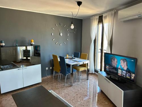 a living room with a dining table and a clock on the wall at El Torreón del Pilar. Opción de parking in Zaragoza