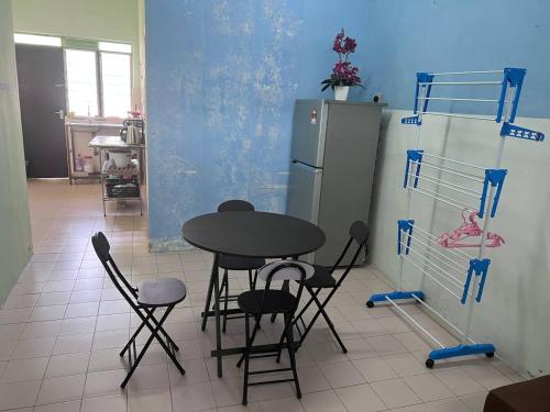 uma cozinha com uma mesa e cadeiras e um frigorífico em Maju Homestay em Gerik
