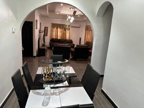 a dining room with two tables and a living room at BENJI'S VILLA in Kumasi