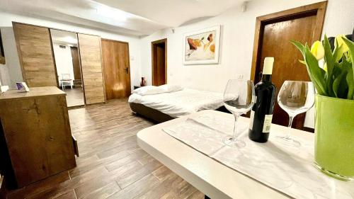 een kamer met een bed en een tafel met wijnglazen bij Ultracentral Apartment in Arad