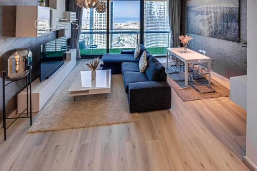 a living room with a blue couch and a table at Burj Vista by Emaar, Downtown Dubai in Dubai