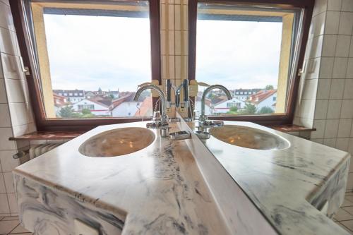 2 umywalki w łazience z 2 oknami w obiekcie ERCK- Flair Hotel & Restaurant w mieście Bad Schönborn
